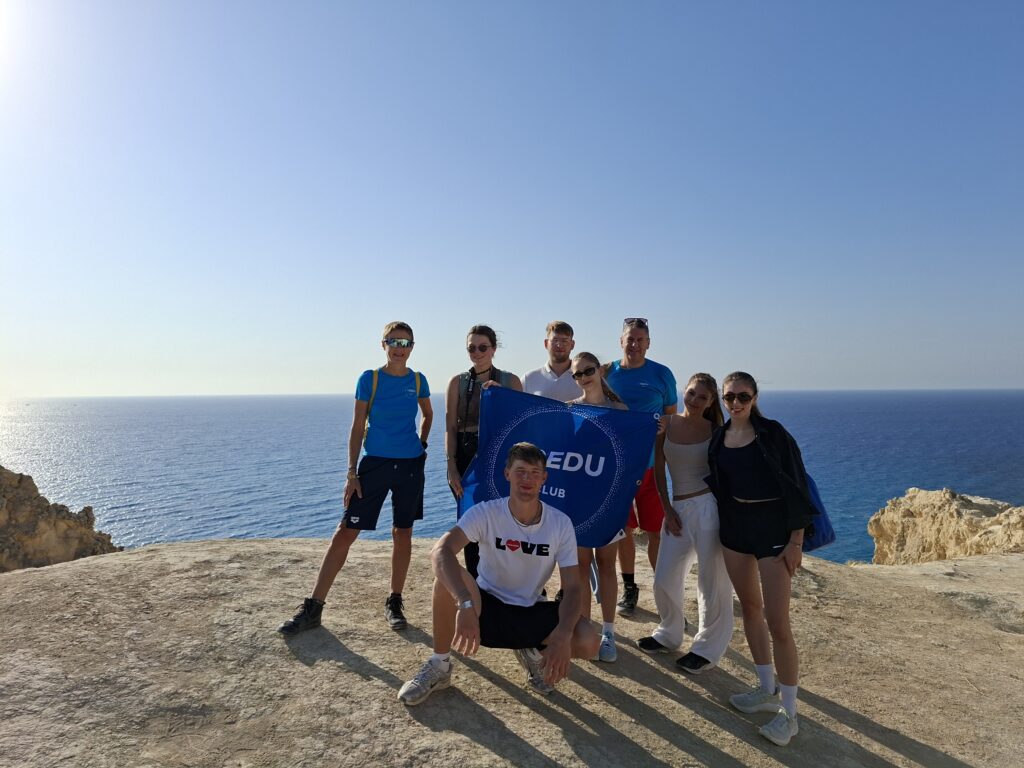 Erasmus+ Tredu Club Gruppe Eine Gruppe junger Menschen mit der Tredu Fahne steht auf einem Kliff